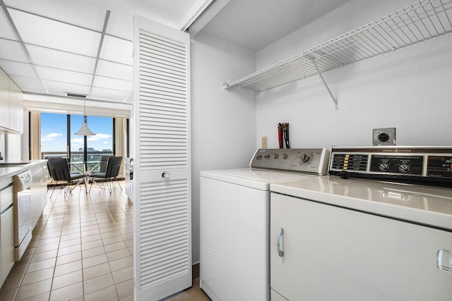 laundry room featuring light tile patterned flooring and separate washer and dryer