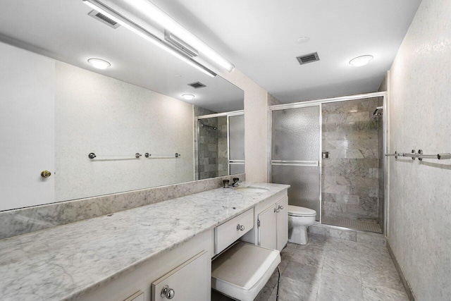 bathroom featuring vanity, toilet, and a shower with door