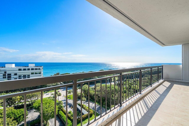 balcony with a water view and a view of the beach