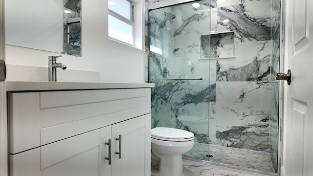 bathroom featuring vanity, toilet, and a shower with shower door