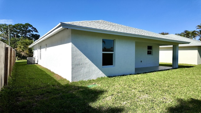 view of side of property with a lawn and central AC unit