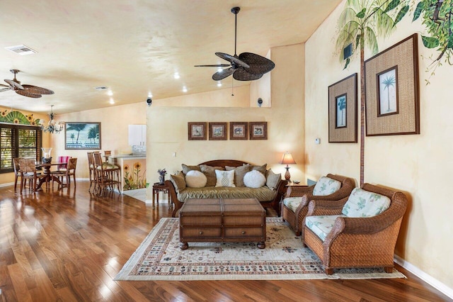 living room with ceiling fan with notable chandelier, wood-type flooring, and vaulted ceiling