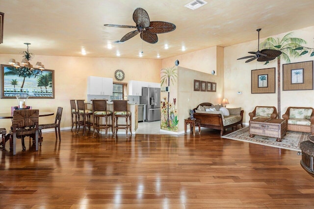 living room featuring hardwood / wood-style flooring and ceiling fan with notable chandelier