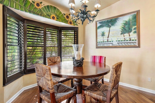 dining area featuring hardwood / wood-style floors and an inviting chandelier