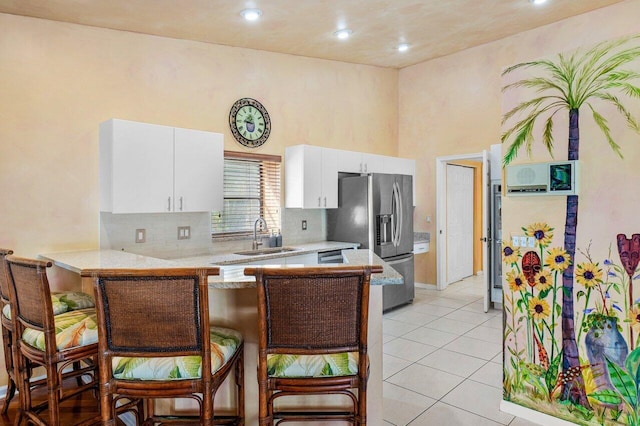 kitchen with white cabinetry, kitchen peninsula, sink, and appliances with stainless steel finishes