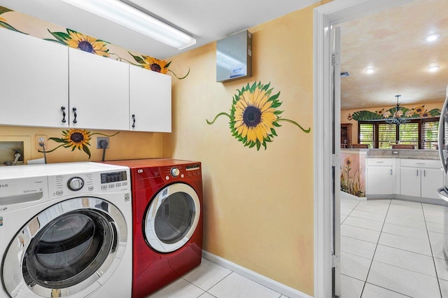 laundry room with washer and dryer, cabinets, light tile patterned floors, and a chandelier