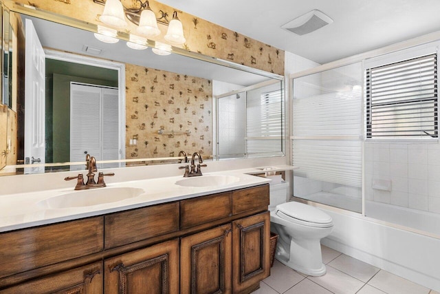 full bathroom with combined bath / shower with glass door, vanity, tile patterned floors, and toilet