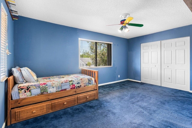 carpeted bedroom with ceiling fan, a textured ceiling, and a closet