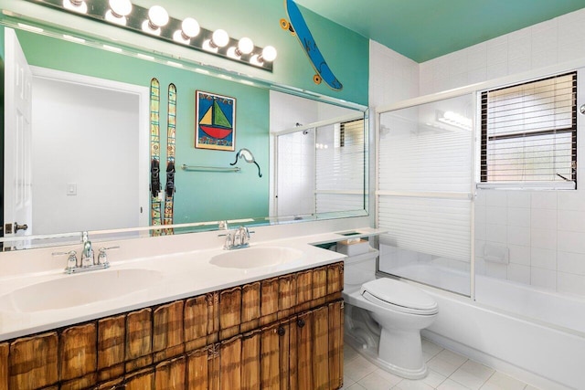 full bathroom featuring tile patterned flooring, vanity, toilet, and bath / shower combo with glass door