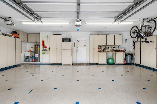 garage with white fridge, sink, a garage door opener, and water heater