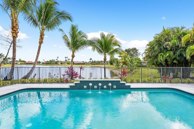 view of swimming pool with pool water feature and a water view