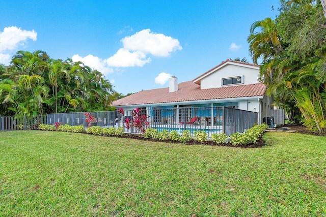 rear view of property featuring central AC unit and a lawn