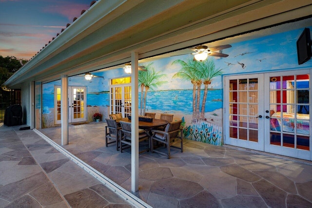 patio terrace at dusk featuring ceiling fan and french doors