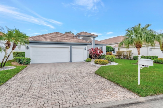 view of front of house featuring decorative driveway, a tile roof, stucco siding, a garage, and a front lawn