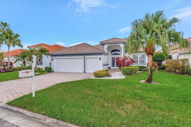 mediterranean / spanish home with a front lawn and a garage