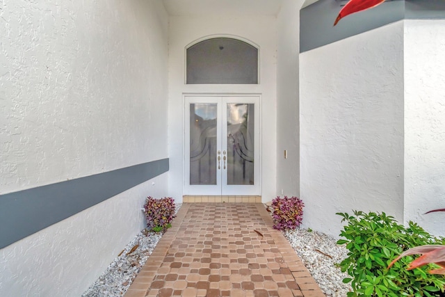 view of exterior entry featuring stucco siding and french doors