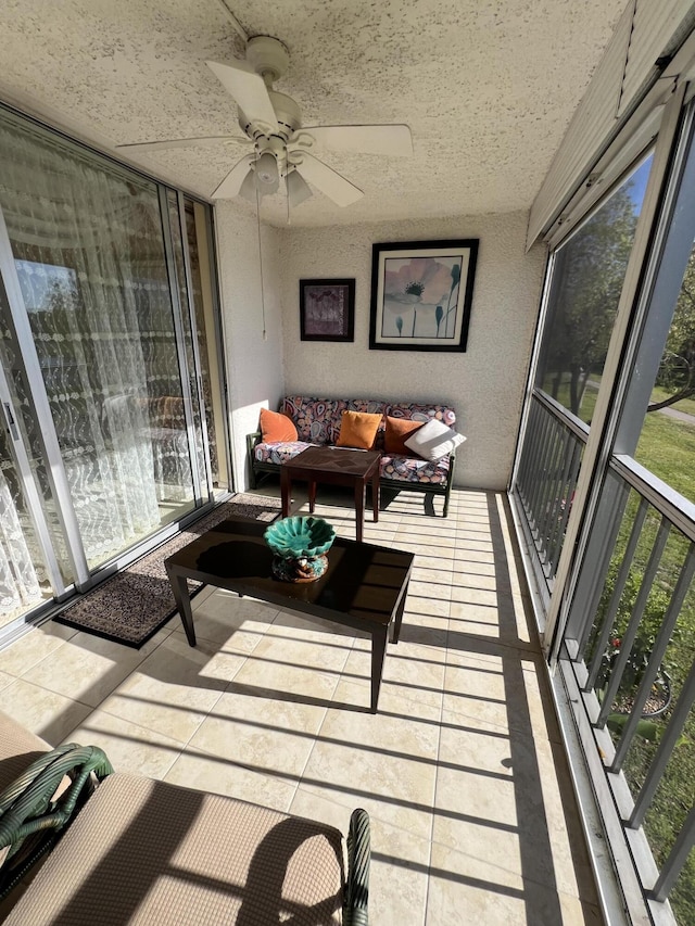 sunroom / solarium with a ceiling fan and an outdoor living space