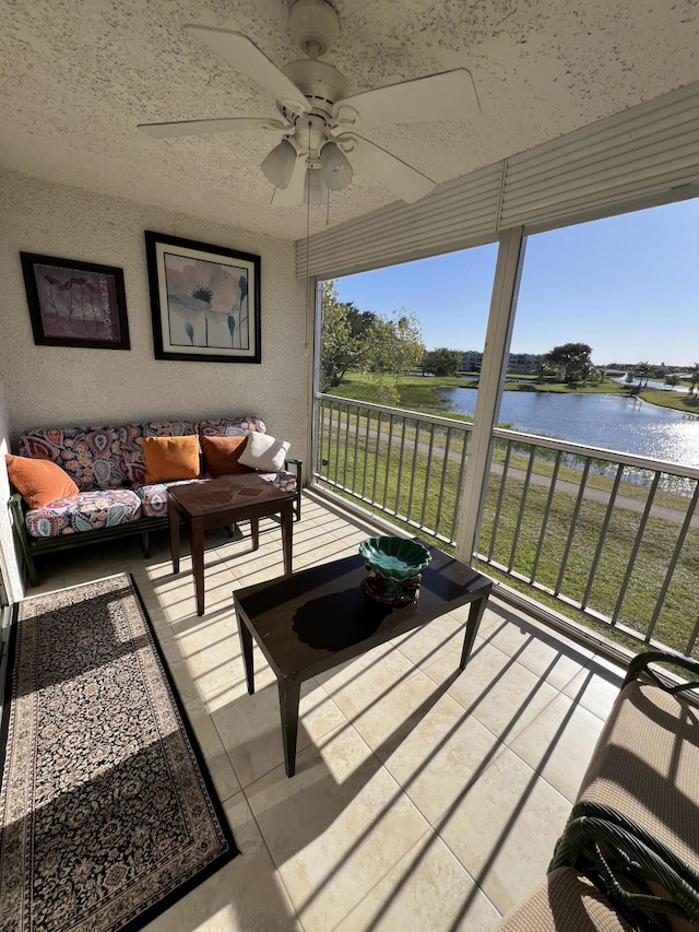 sunroom / solarium featuring an outdoor living space, a ceiling fan, and a water view