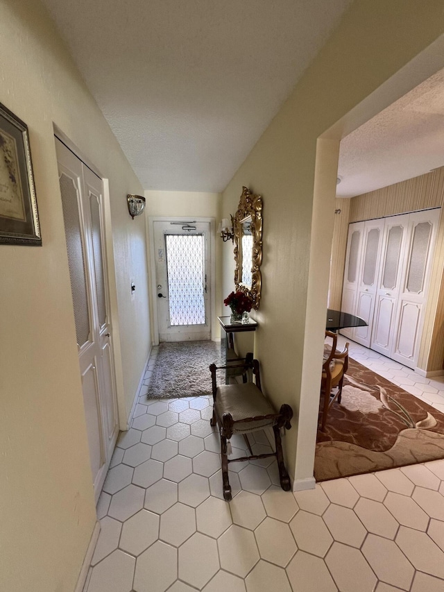 hall with baseboards and light tile patterned floors