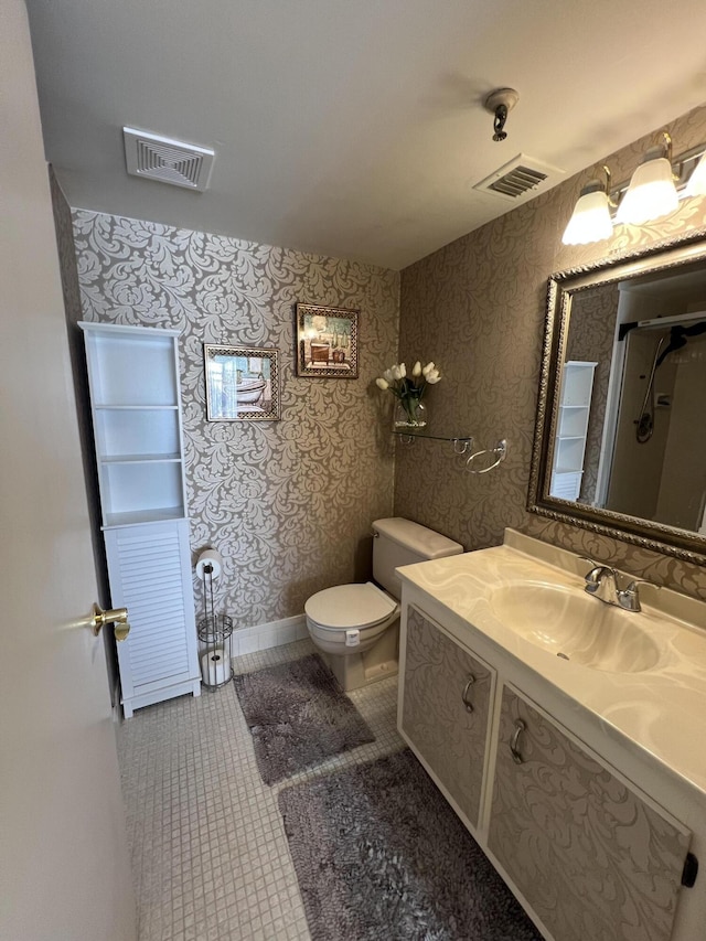 bathroom with toilet, vanity, visible vents, and tile patterned floors