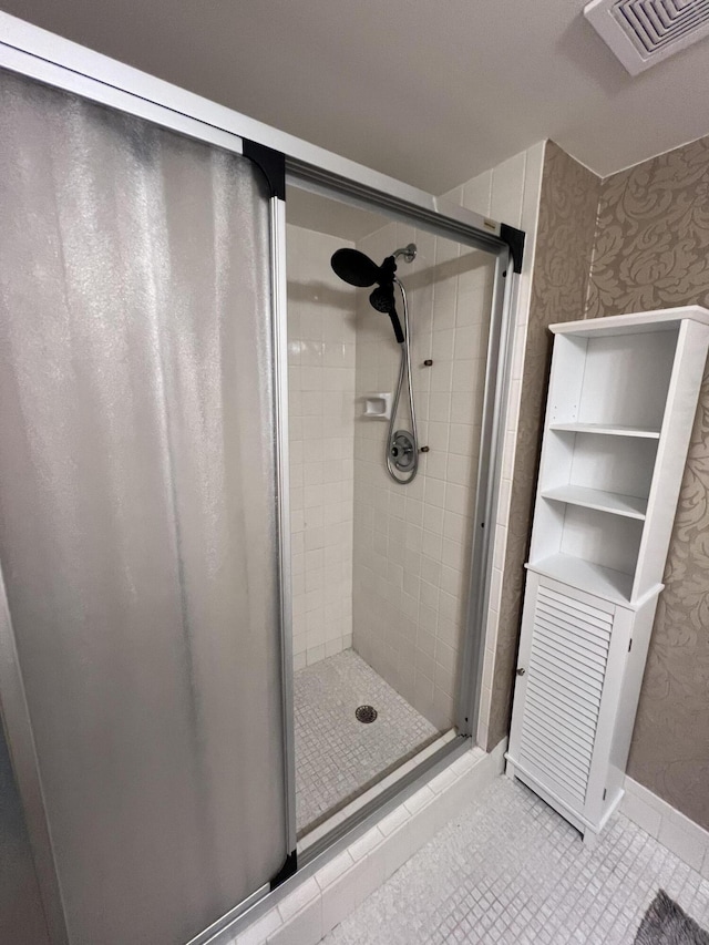 bathroom featuring tile patterned floors, wallpapered walls, and a shower stall