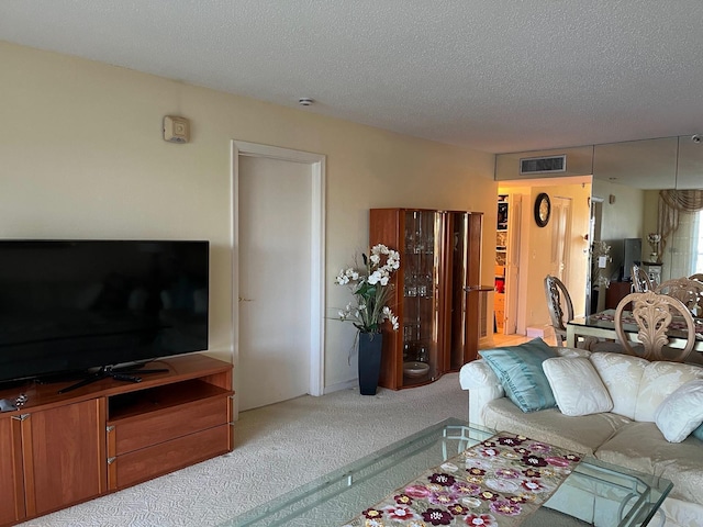 carpeted living area with visible vents and a textured ceiling