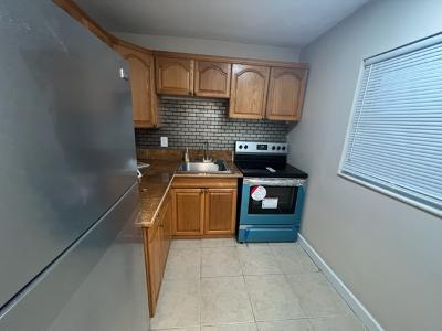 kitchen with decorative backsplash, sink, light tile patterned flooring, and stainless steel appliances