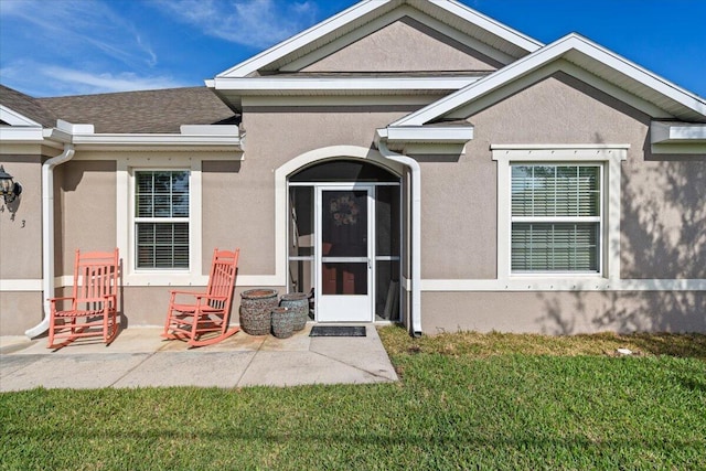 property entrance with a patio area and a yard