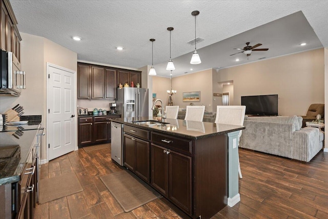 kitchen featuring dark brown cabinets, sink, an island with sink, and stainless steel appliances