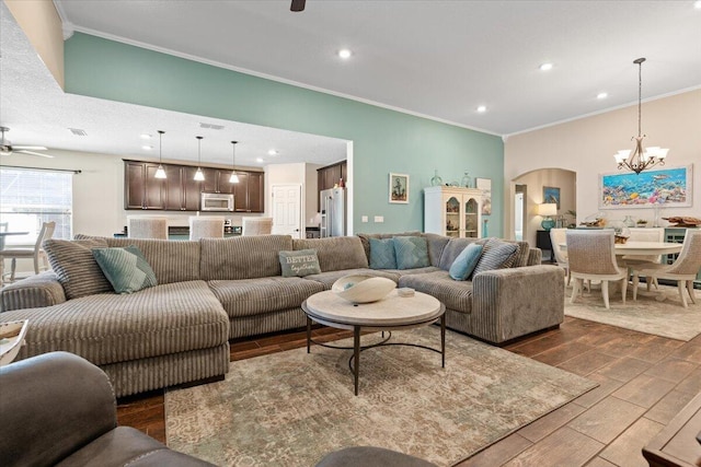 living room featuring ceiling fan with notable chandelier and ornamental molding