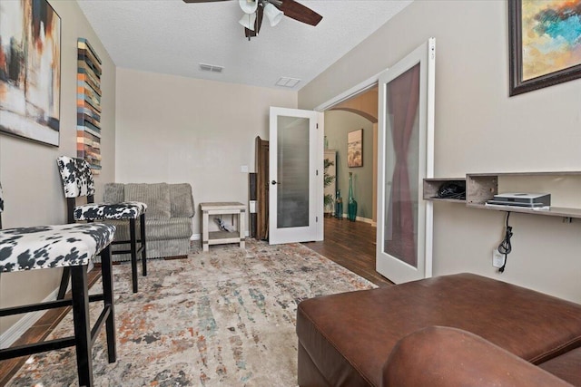 office space with french doors, a textured ceiling, ceiling fan, and wood-type flooring