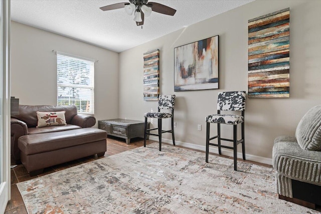 sitting room featuring hardwood / wood-style floors, a textured ceiling, and ceiling fan