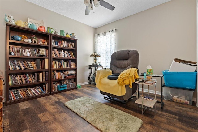 sitting room with a textured ceiling, ceiling fan, and dark wood-type flooring