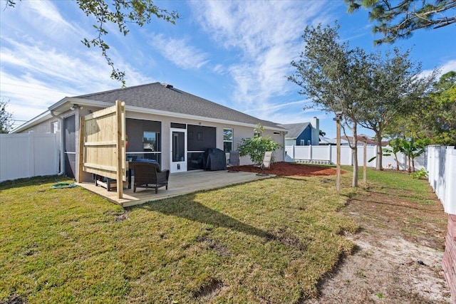 rear view of house with a lawn, a patio area, and a sunroom