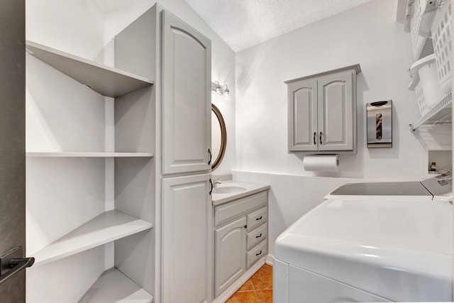 washroom with sink, light tile patterned flooring, cabinets, and a textured ceiling