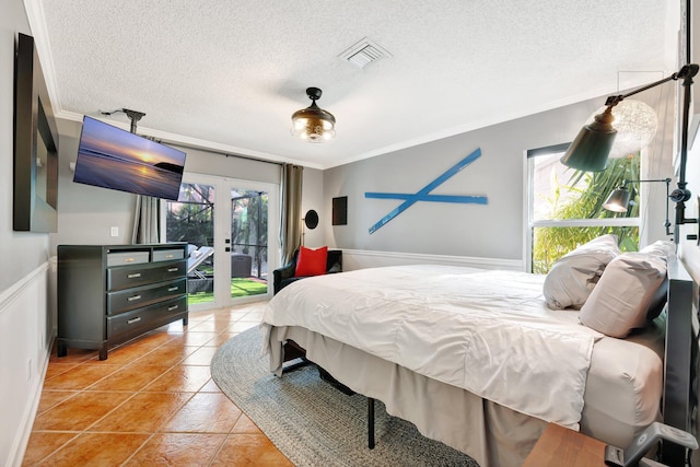 bedroom featuring french doors, access to exterior, ornamental molding, light tile patterned floors, and a textured ceiling