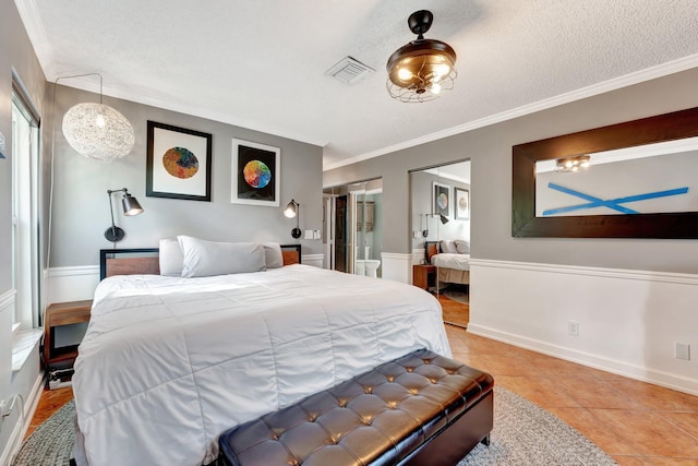 bedroom with a textured ceiling, ornamental molding, and light tile patterned flooring