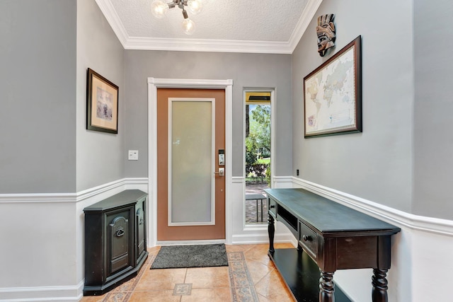 tiled entrance foyer featuring a textured ceiling and ornamental molding