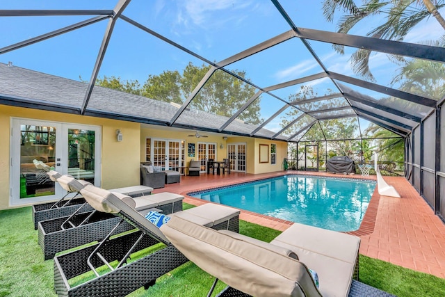 view of pool featuring french doors, an outdoor hangout area, ceiling fan, glass enclosure, and a patio