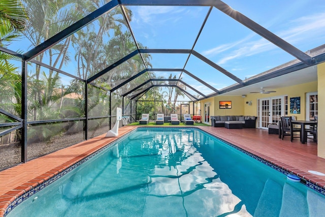 view of swimming pool featuring a lanai, outdoor lounge area, ceiling fan, and french doors