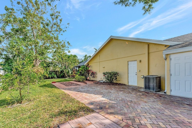 view of yard with central air condition unit and a patio