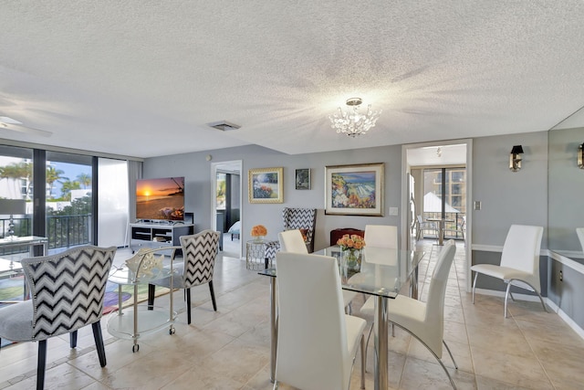 tiled dining room featuring floor to ceiling windows, a textured ceiling, and an inviting chandelier