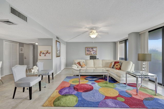 living room with a textured ceiling and ceiling fan