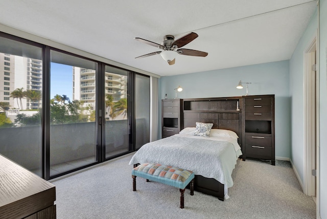 carpeted bedroom featuring expansive windows, access to outside, and ceiling fan