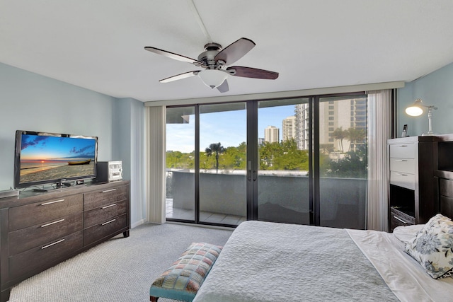 carpeted bedroom with ceiling fan, expansive windows, and access to exterior