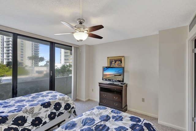 carpeted bedroom with access to outside, ceiling fan, and a textured ceiling