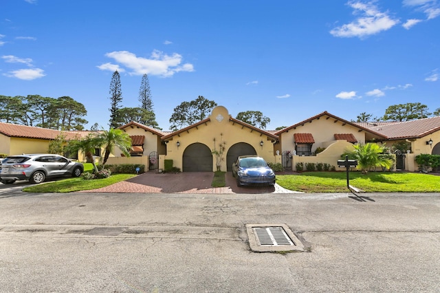 mediterranean / spanish house with a garage and a front lawn