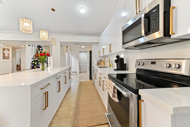 kitchen with white cabinets, hanging light fixtures, decorative backsplash, a kitchen island, and stainless steel appliances