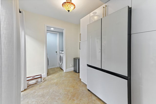 5272 Bolero Cir, Delray Beach, FL 33484 - hall with washer / dryer, baseboards, and light tile patterned floors