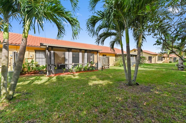 5272 Bolero Cir, Delray Beach, FL 33484 - rear view of property with a sunroom, a tiled roof, a yard, and stucco siding